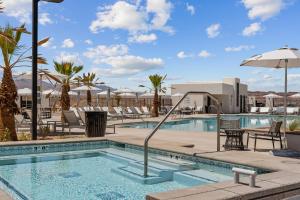een zwembad in een resort met stoelen en een parasol bij Southern Solace condo in St. George
