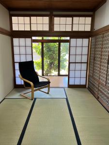 a room with a chair in a room with windows at ＳｅａＳａｉｄｅＨｏｕｓｅ湯河原 in Yugawara