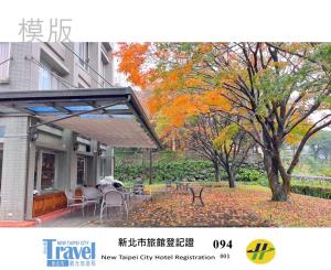 三芝乡虹桥民宿的一栋带露台的房子和一棵地上长满树叶的树