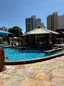 a swimming pool with a gazebo in a city at Thermas Place Flat in Caldas Novas +9 photos