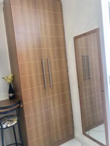 a wooden closet with a glass door in a room at Thermas Place Flat in Caldas Novas