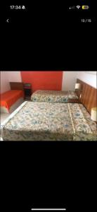 two beds in a room with red walls at Thermas Place Flat in Caldas Novas