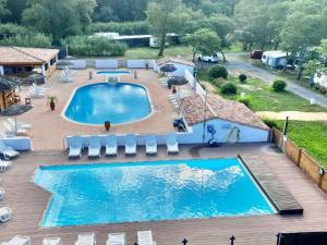 an overhead view of a large swimming pool on a deck at Mobil-home confortable avec terrasse pour 4 personnes - API-1-52-413 in Massillargues-Attuech