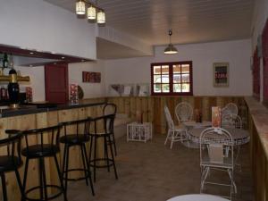 a room with a bar with chairs and a table at Mobil-home confortable avec terrasse pour 4 personnes - API-1-52-413 in Massillargues-Attuech