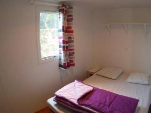 a small room with a bed and a window at Mobil-home avec Terrasse - 4 pers, 2 ch - API-1-52-451 in La Mothe-Achard