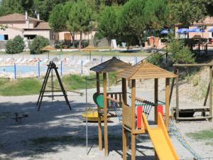un parque infantil con tobogán y columpios en Chalet spacieux avec terrasse pour 6 personnes - API-1-52-482, en Saint-Maime