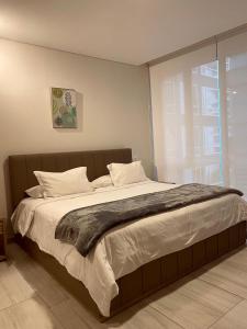 a bedroom with a large bed with white pillows at Luxury Apartment Leparc Residences in Quito +21 photos