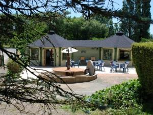 una casa con patio arredato con tavolo e sedie di Mobil-home 4 pers avec terrasse au camping Les Tournesols - API-1-52-489 a Crissé