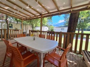 a white table and chairs on a wooden deck at Mobil-home 3 chambres avec terrasse à Valbonnais - API-1-52-473 in Valbonnais +15 photos