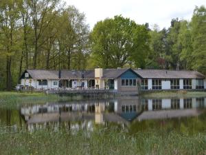 a house on the side of a lake at Holiday Home in Stramproy near Nature in Stramproy