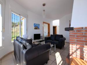 a living room with two leather couches and a tv at Villa in Arenas with Sea Views and Private Pool in Arenas