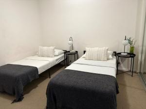 two beds sitting next to each other in a room at Modern 2B1B Apt Southbank Next to Crown W Parking in Melbourne +8 photos