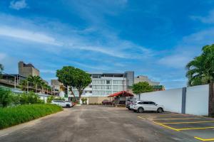 那牙The Isabelle Hotel的建筑物前停放汽车的停车场