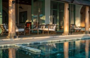 a swimming pool with chairs and a table at Candella House in Talpe