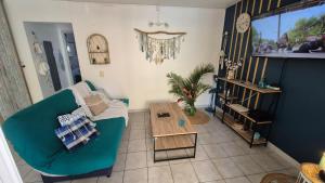 a living room with a green couch and a table at TI BLUE plage à proximité in Les Trois-Îlets