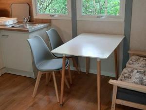 a small kitchen with a white table and chairs at Chalet 3 chambres avec terrasse pour 5 personnes - API-1-52-617 in Rives +24 photos