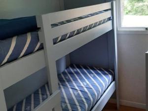 a childs bunk bed with a blue and white bunk bed at Chalet 3 chambres avec terrasse pour 5 personnes - API-1-52-617 in Rives