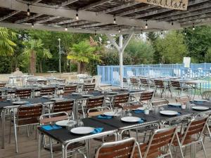 a group of tables and chairs under a marquee at Chalet 3 chambres avec terrasse pour 5 personnes - API-1-52-617 in Rives
