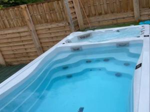 una vasca idromassaggio con acqua blu in un cortile di Maison spacieuse à Jumièges, 6 pers, 3 chambres - API-1-52-639 a Jumièges