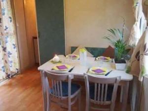 une table à manger avec des chaises et une table blanche dans l'établissement Mobil-home 7 pers avec terrasse - API-1-52-737, à Esparron-de-Verdon 14 autres photos