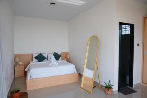 a bedroom with a bed and a mirror at Habitat Boutique Dive Resort in Tulamben