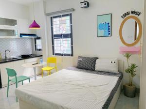 a small room with a bed and a kitchen at Corgi House Central Nha Trang in Nha Trang