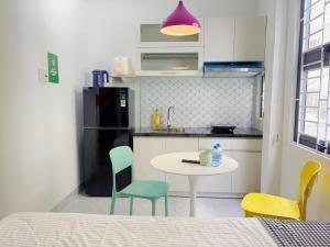a kitchen with a table and chairs and a refrigerator at Corgi House Central Nha Trang in Nha Trang