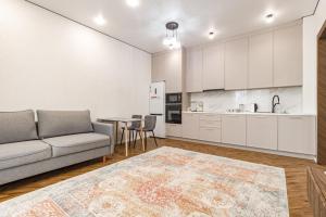 a living room with a couch and a table at GreenLine Atmosfera luxe 2 bedroom apartment in Zhezdi
