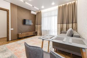 a living room with a couch and a table at GreenLine Atmosfera luxe 2 bedroom apartment in Zhezdi