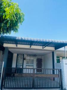 a house with a porch with a wooden fence at ZuLee Homestay in Lunas