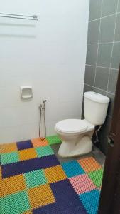 a bathroom with a toilet and a colorful floor at ZuLee Homestay in Lunas +2 photos