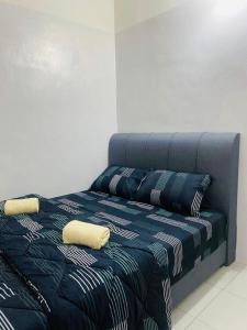 a bed with two pillows on top of it at ZuLee Homestay in Lunas