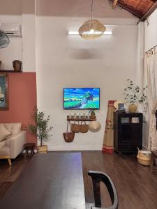 a living room with a flat screen tv on a wall at Peaceful Vietnamese - Style House, Yard & Bathtub in Da Nang