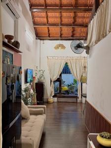a living room with a couch and a window at Peaceful Vietnamese - Style House, Yard & Bathtub in Da Nang