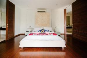 a bedroom with a large white bed with a red and white blanket at C151 Smart Villas at Seminyak in Seminyak