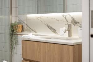 ein Badezimmer mit Waschbecken und Spiegel in der Unterkunft Chic Inner North Escape,Dickson n ANU ,Parking in Downer + 26 Fotos