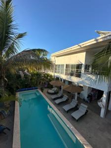 ein Swimmingpool mit Stühlen und Sonnenschirmen neben einem Haus in der Unterkunft Casa Brisa in Lo de Marcos