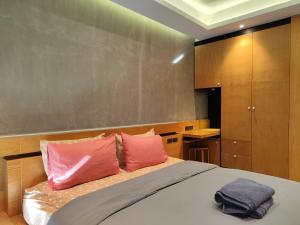 a bedroom with a bed with pink and purple pillows at Nai Harn beach - Studio room on 2 floor at ReLife The Windy in Rawai Beach