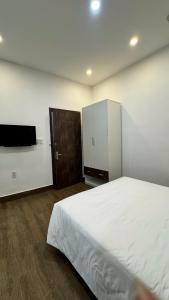 a bedroom with a large bed and a cabinet at Hoàng Anh Apartment in Da Nang
