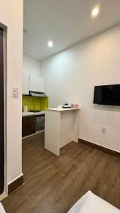 a room with a kitchen with a counter and a tv at Hoàng Anh Apartment in Da Nang +7 photos