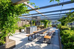 eine Terrasse mit Bänken und Pflanzen in einem Gebäude in der Unterkunft Chic Inner North Escape,Dickson n ANU ,Parking in Downer