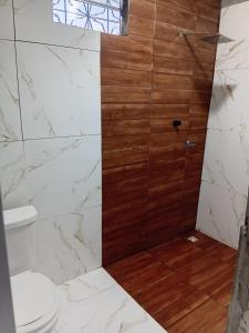 a bathroom with a toilet and a shower with wood at Casa em salinas in Salinópolis +4 photos
