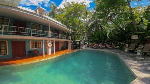 a swimming pool in front of a house at Oceanfront Hotel Verde Mar direct access to the beach in Manuel Antonio
