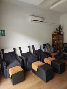 a living room with a black couch and chairs at Ln House Chiang Mai in Chiang Mai +46 photos