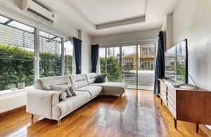a living room with a couch and a tv at The SkyLanna Pool Villa Chiang Mai in Mae Rim