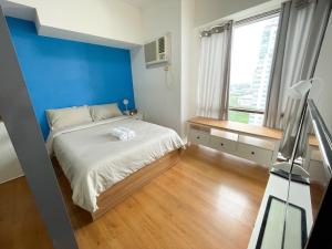 a bedroom with a bed with a blue wall at 1 BR Condo in Manila near US Embassy & St Lukes in Manila