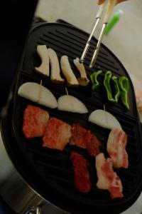 a black plate of food with meat and vegetables at 塩原温泉アクティビティクラブ in Shiobara-machi