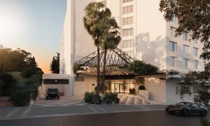 a car parked in front of a building with a palm tree at InterContinental Sydney Coogee Beach by IHG in Sydney +2 photos