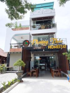 Un restaurante con mesas y sillas frente a un edificio. en Tam Cốc Phương Thảo Homestay, en Ninh Binh