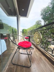 una silla roja en la parte superior de un balcón en Tam Cốc Phương Thảo Homestay, en Ninh Binh